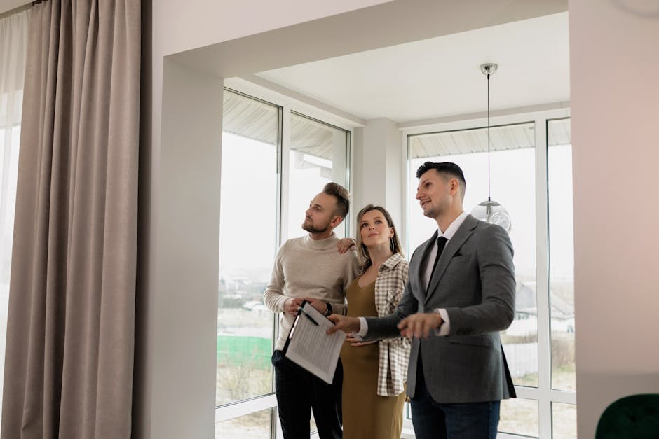A real estate agent showing a modern home to a young couple during a daytime viewing