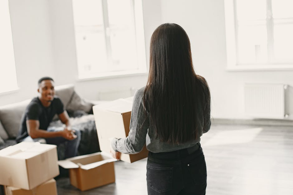 Couple working together to unpack moving boxes in their new home