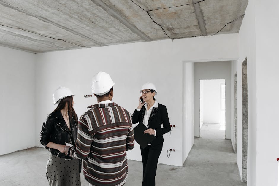 Real estate agent discussing with clients inside an empty property under construction