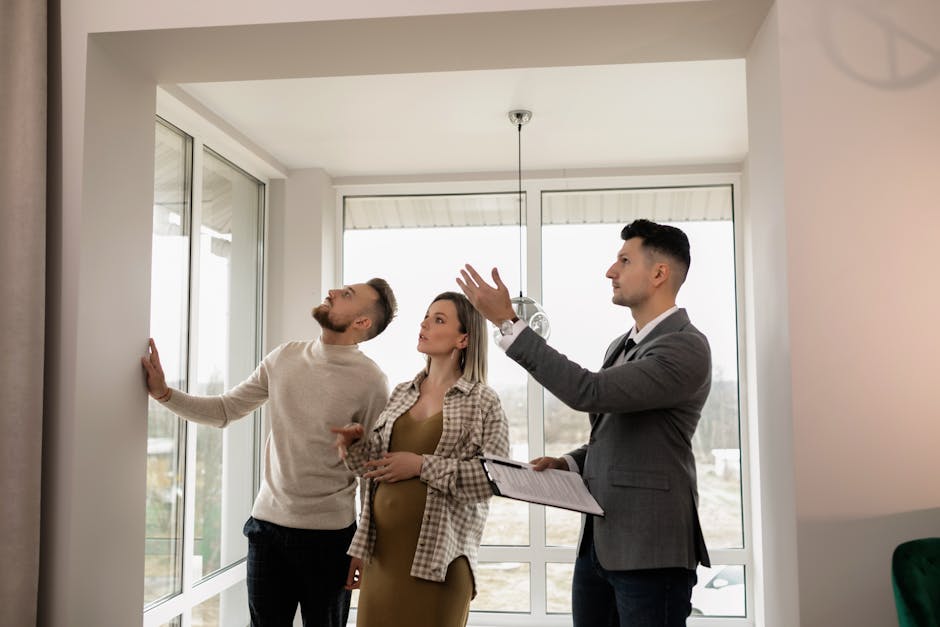 A young couple inspects a modern apartment with a real estate agent during a daytime viewing