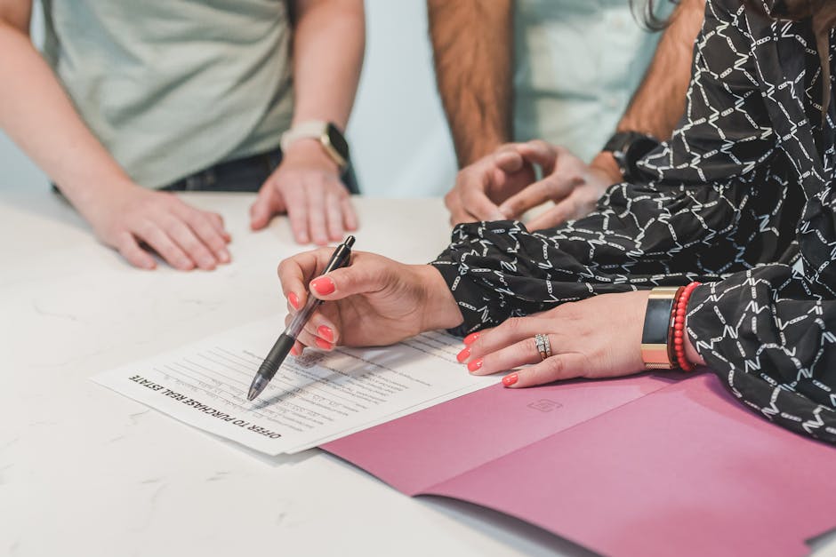 Hands signing a real estate counter offer document during a negotiation meeting