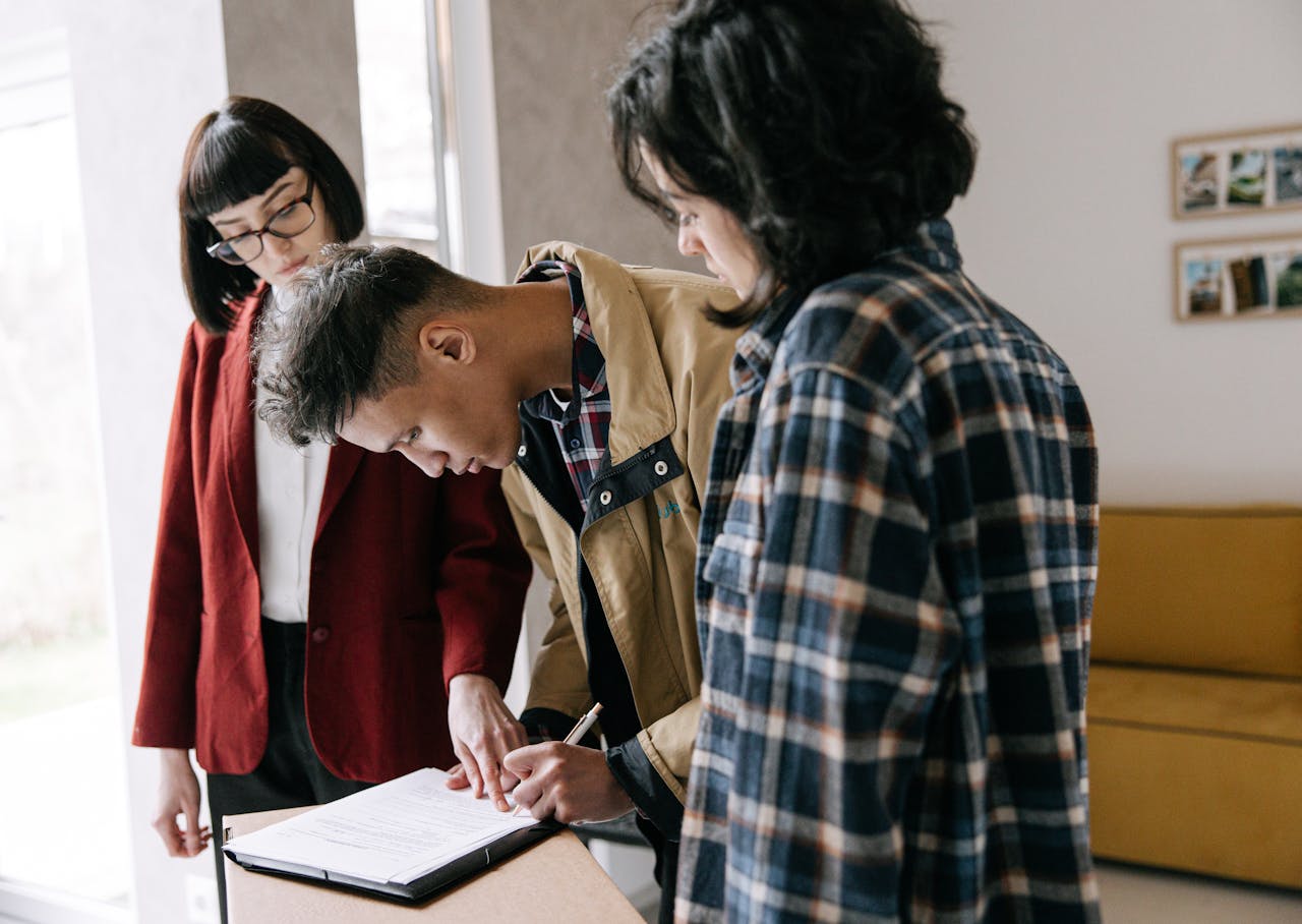 Couple reviewing and signing a real estate commission agreement with their agent