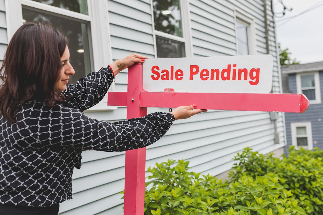 Sale pending sign in front of a house after successful offer