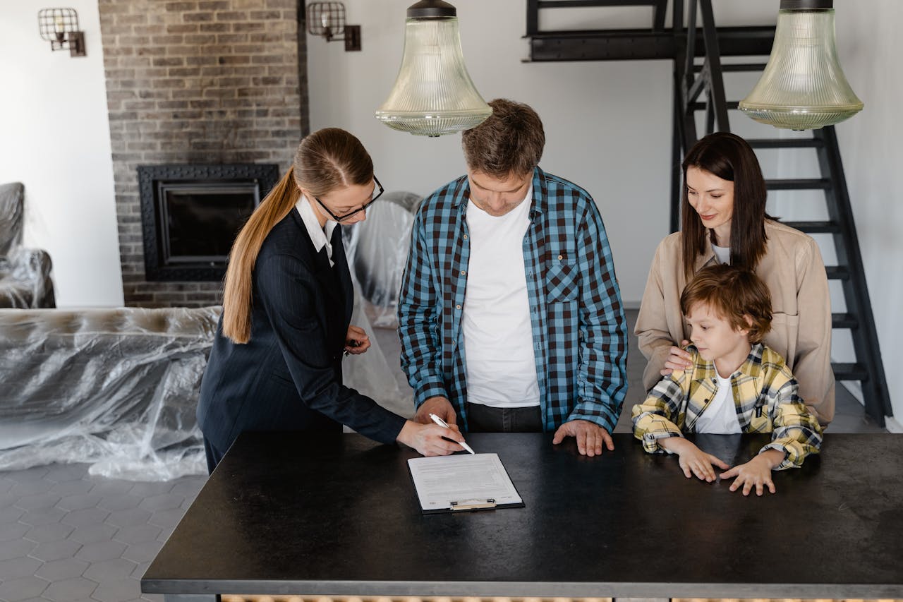 Family happily signing a real estate contract after successful commission negotiation