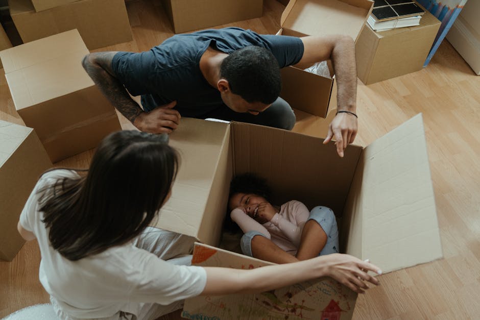 Family with moving boxes comparing the costs of renting versus buying their home