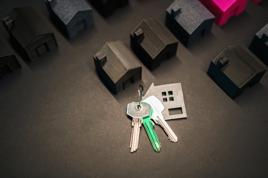 Miniature house models and keys representing real estate investment options