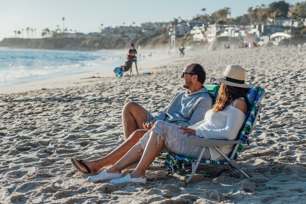 Senior couple relaxing in beach chairs by the ocean during retirement